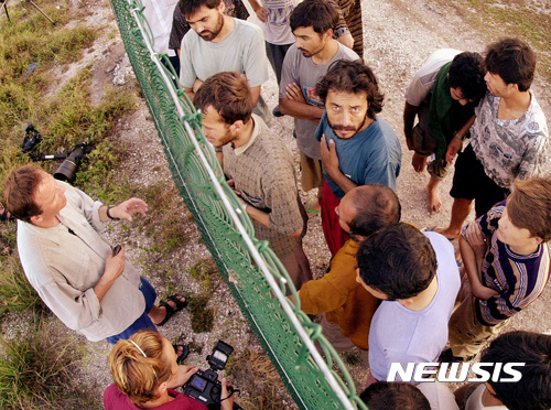 【나우루=AP/뉴시스】 지난 2001년 9월 19일 나우루 섬 내의 난민수용소에 있는 난민들(오른쪽)이 철조망을 사이에 두고 기자들의 취재에 응하고 있는 모습. 호주는 자국에 불법입국하는 난민 및 이주민들을 인근 나우루와 파푸아뉴기니 마누스 섬 등 역외수용소에 수용해오고 있다.&nbsp; 2017.02.10 