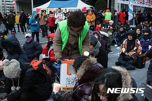 【대전=뉴시스】조명휘 기자 = 11일 오후 대전시 서구 둔산동 타임월드 앞에서 열린 박근혜 대통령 탄핵을 촉구하는 제12차 대전시국대회에서 자원봉사자가 시민들을 상대로 모금활동을 하고 있다. 2017.02.11. joemedia@newsis.com