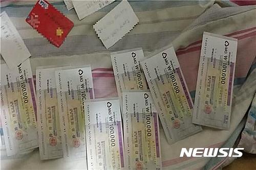 【파주=뉴시스】이경환 기자 = 경기 파주경찰서는 여성과 나체로 스마트폰 영상채팅을 하면서 음란행위를 유도하고 이를 녹화해 유포하겠다고 협박하는 이른바 '몸캠피싱' 등으로 1억8000만원을 빼돌린 인출책 조모(31·중국인)씨를 구속했다고 21일 밝혔다. 사진은 검거 당시 조씨가 갖고 있던 수표와 현금카드이다. 2017.02,21.(사진=파주경찰서 제공)&nbsp; lkh@newsis.com 