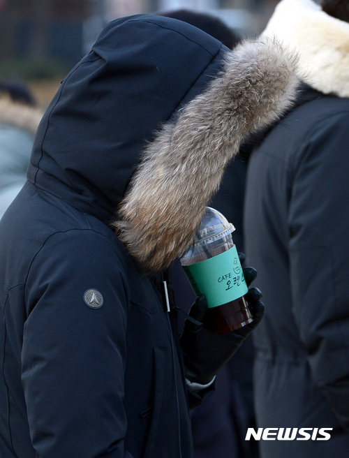 【서울=뉴시스】이영환 기자 = 서울 종로구 광화문 네거리에서 한 시민이 털모자를 착용하고 아이스 커피를 마시고 있다. 2017.02.21. 20hwan@newsis.com