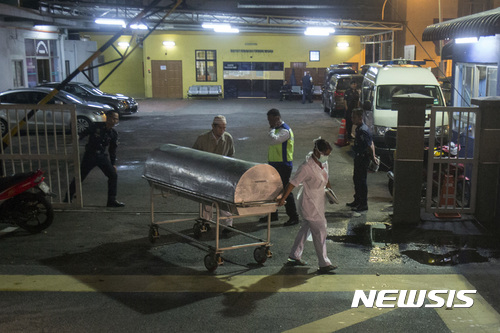 【쿠알라룸푸르=AP/뉴시스】김정남 시신 부검이 진행된 말레이시아 쿠알라룸푸르병원 앞에서 22일 국립부검연구소 소속 직원이 시신이 들어있는 것으로 추정되는 금속 통이 실린 카트를 끌고 가고 있다. 2017.02.22