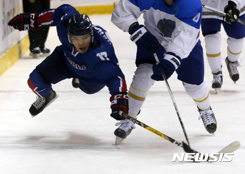 South Korea's Shin Sang-hoon, left, and Kazakhstan's Madiyar Ibraibekov fight for the puck during a match of the ice hockey men't top division at the Asian Winter Games in Sapporo, northern Japan, Wednesday, Feb. 22, 2017. (AP Photo/Shuji Kajiyama)