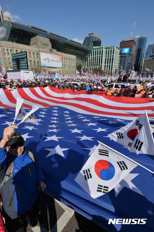 【서울=뉴시스】고승민 기자 = 대통령탄핵기각을위한국민총궐기운동본부가 25일 오후 서울광장과 대한문 앞에서 14차 탄핵반대 집회를 열고 있다. 참가자들이 대형 성조기를 들고 있다. 2017.02.25.&nbsp; kkssmm99@newsis.com