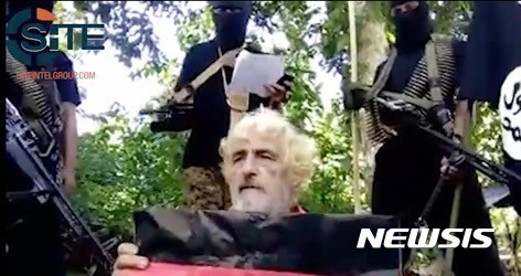 【AP/뉴시스】24일 SITE 정보 그룹이 공개한 날짜 미상의 사진으로, 독일 인질 유르겐 칸트너가 필리핀 이슬람 극단조직 아부 사이아프 대원 사이에 앉아 있다. 이 조직이 27일 몸값이 지불되지 않았다면서 인질을 참수하는 비디오가 유포됐다. 2017. 2. 27.&nbsp;&nbsp; 