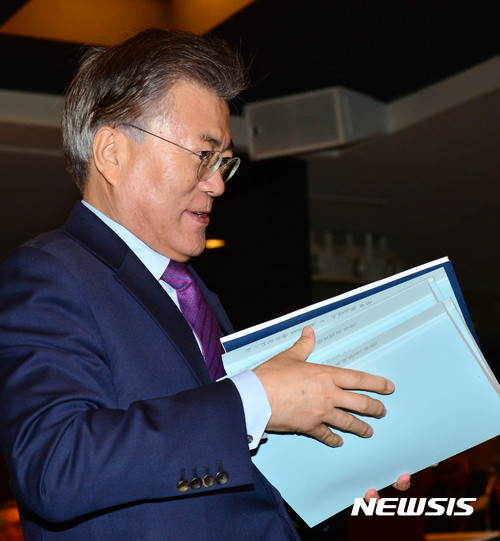 【서울=뉴시스】박진희 기자 = 문재인 전 더불어민주당 대표는 28일 오후 서울 종로구 세종문화회관 세종홀에서 열린 '정책공간 국민성장' 회원의 날에 참석하여 회원들이 만든 정책제안서를 들고 있다. 2017.02.28.&nbsp; pak7130@newsis.com