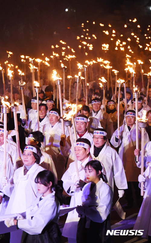 【천안=뉴시스】함형서 기자 = 제98주년 3·1절을 하루 앞둔 28일 오후 충남 천안시 동남구 병천면 사적관리소 앞에서 열린 아우내 봉화제에서 참가자들이 대형 태극기를 앞세우며 횃불을 들고 행진을 하고 있다. 2017.02.28. foodwork23@newsis.com