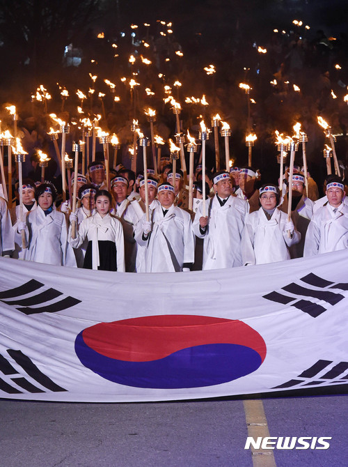 【천안=뉴시스】함형서 기자 = 제98주년 3·1절을 하루 앞둔 28일 오후 충남 천안시 동남구 병천면 사적관리소 앞에서 열린 아우내 봉화제에서 참가자들이 대형 태극기를 앞세우며 횃불을 들고 행진을 하고 있다. 2017.02.28. foodwork23@newsis.com