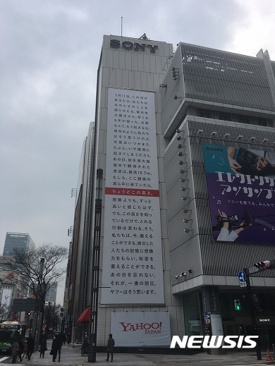 【서울=뉴시스】야후 재팬이 동일본 대지진을 기억하기 위해 도쿄(東京) 긴자(銀座)에 위치한 소니빌딩 벽면에 내건 광고. 광고판 중간에 붉은색으로 표신된 부분은 16.7m 높이로, 동일본 대지진 당시 가장 높은 쓰나미(지진해일) 높이를 표시한 것.(사진출처: 일본 네토라보) 2017.03.07.