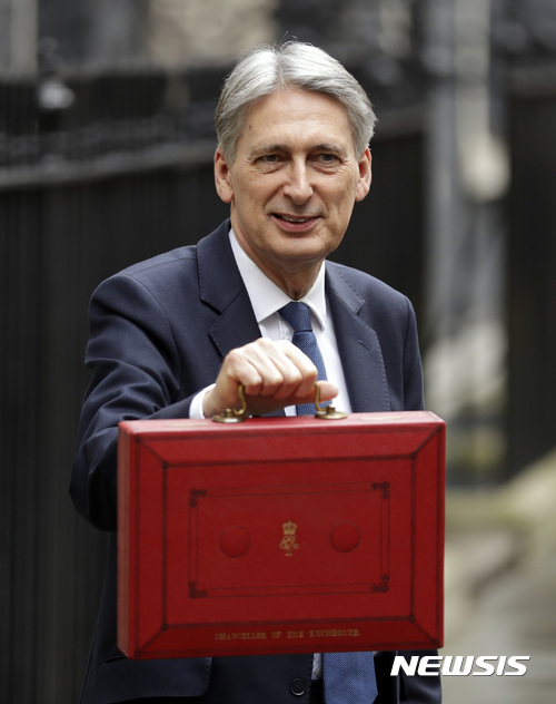 【런던=AP/뉴시스】필립 해먼드 영국 재무장관이 8일(현지시간) 런던에 잇는 총리실 관저 밖에서 자신의 공문서 서류가방을 기자들에게 보여주고 있다. 그는 이날 의회 연설에서 영국의 유럽연합(EU) 탍퇴에 대비해 “EU를 밖에서 더 강하고 공정하며 더 나은 영국의 토대 마련”을 위한 2017~18 회계연도 예산안을 발표했다. 2017.03.09