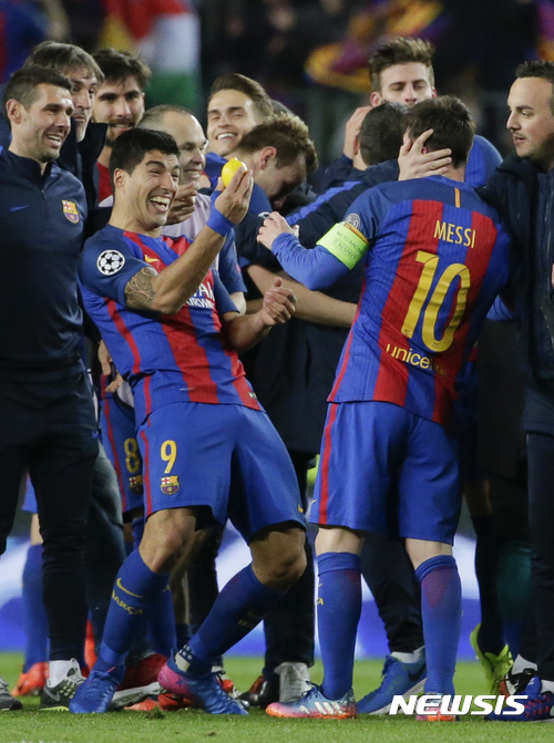Barcelona's Luis Suarez, left, holds a lemon as he celebrates with his teammate Lionel Messi at the end of the Champions League round of 16, second leg soccer match between FC Barcelona and Paris Saint Germain at the Camp Nou stadium in Barcelona, Spain, Wednesday March 8, 2017. Barcelona won 6-1. (AP Photo/Emilio Morenatti)