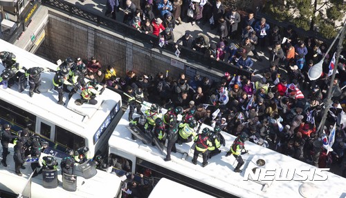 【서울=뉴시스】사진공동취재단 = 10일 오후 서울 재동 헌법재판소 앞에서 박근혜 대통령의 탄핵이 인용 되자 보수단체 회원들이 차벽을 부수고 헌재로 진입하고 있다. 2017.03.10.&nbsp;&nbsp; photo@newsis.com