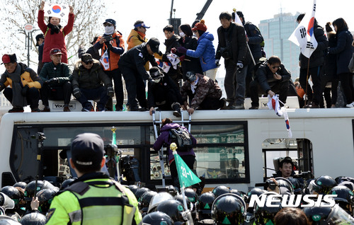 【서울=뉴시스】홍찬선 기자 = 헌재가 박근혜 대통령의 탄핵을 인용을 결정했다. 즉 사상 첫 탄핵심판으로 파면당한 대통령으로 기록되게 됐다.&nbsp; 10일 오후 서울 종로구 헌법재판소 앞 도로에서 탄핵 인용에 항의하는 시민들이 태극기를 들고 헌재로 진입을 시도, 이를 막는 경찰들과 대치를 벌이고 있다. 2017.03.10.&nbsp; mania@newsis.com 