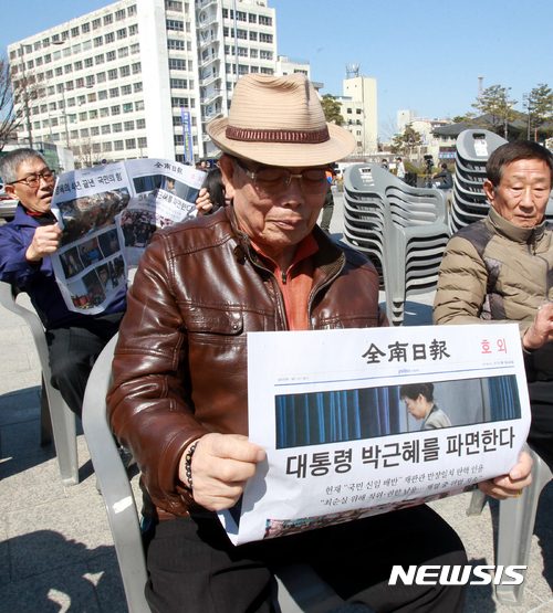 【광주=뉴시스】배동민 기자 = 10일 오후 광주 동구 옛 전남도청 앞 5·18민주공장에서 광주 시민들이 전남일보가 발행한 '박근혜 대통령 파면' 호외를 읽고 있다. 2017.03.10. guggy@newsis.com