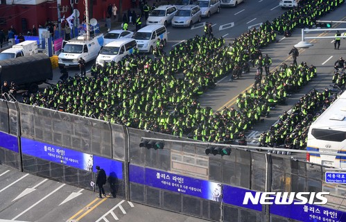 【서울=뉴시스】사진공동취재단 = 박근혜 전 대통령의 탄핵 인용 다음날인 11일 서울 시청광장 일대에서 탄핵무효국민총궐기운동본부가 주최하는 태극기 집회가 열린 가운데 한 참가자가 태극기를 들고 폴리스라인을 바라보고 있다. 2017.03.11.   photo@newsis.com