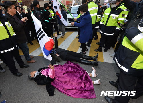 【서울=뉴시스】고승민 기자 = 14일 오후 서울 삼성동 박근혜 전 대통령 사저 앞에서 JTBC 취재차량이 들어서자 극도로 흥분한 박 전 대통령 지지자들이 이를 막기 위해 바닥에 드러누워 "나를 밟고 지나가라"며 태극기를 흔들고 있다. 2017.03.14.&nbsp; kkssmm99@newsis.com