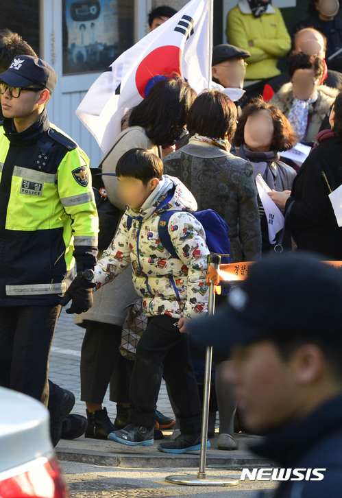 【서울=뉴시스】최동준 기자 = 14일 오후 서울 삼성동 박근혜 전 대통령 사저 앞에서 집회, 시위 중인 박 전 대통령 지지자들 사이로 한 어린이가 집으로 돌아가고 있다. 연일 이어지는 지지자들의 집회와 고성으로 주민들 원성이 높아지고 있으며 근처 초등학교에서 통학하는 학생들의 피해가 우려된다. 2017.03.14.&nbsp; photocdj@newsis.com