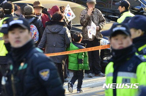 【서울=뉴시스】최동준 기자 = 14일 오후 서울 삼성동 박근혜 전 대통령 사저 앞에서 집회, 시위 중인 박 전 대통령 지지자들 사이로 한 어린이가 집으로 돌아가고 있다. 연일 이어지는 지지자들의 집회와 고성으로 주민들 원성이 높아지고 있으며 근처 초등학교에서 통학하는 학생들의 피해가 우려된다. 2017.03.14.&nbsp; photocdj@newsis.com