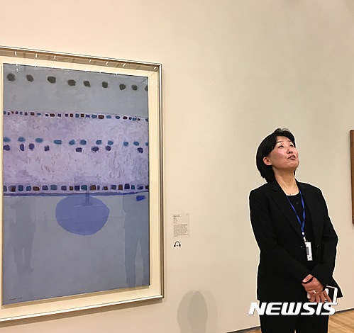 【서울=뉴시스】박현주 기자= 박미화 국립현대미술관 학예연구관이 이번 신소장품전중 최고가(13억)인 김환기의 새벽을 위해 두대의 조명을 설치했다고 설명하고 있다.