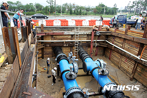 【청주=뉴시스】천영준 기자 = 18일 충북 청주시에 따르면 2015년 8월 1일 통합정수장 도수관로 연결공사 과정에서 누수가 발생해 상당구와 청원구, 서원구 산남·수곡·분평동 지역 1만7406가구와 2504개 영업장이 수돗물을 공급받지 못해 불편을 겪었다. 사진은 2015년 8월 2일 청주시 관계자들과 지역 주민들이 송수관 보수 작업을 지켜보고 있는 모습. 2017.7.18. (사진=뉴시스 DB) photo@newsis.com