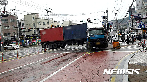 【부산=뉴시스】하경민 기자 = 21일 오전 6시 5분께 부산 기장군 기장읍의 한 교차로에서 트레일러가 빗길에 미끄러져 신호등을 들이받는 사고가 났다. 2017.03.21. (사진=부산경찰청 제공)   yulnetphoto@newsis.com