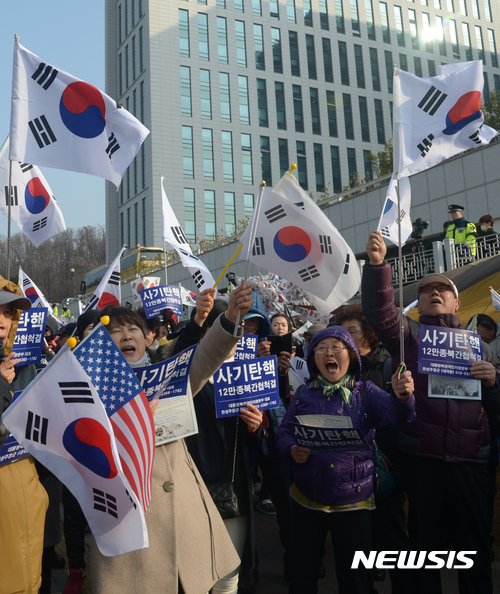 【서울=뉴시스】조수정 기자 = 박근혜 전 대통령이 검찰 조사를 받기 위해 출두한 21일 오전 서울 서초동 중앙지검 청사 앞에서 대통령복권국민저항본부 회원들이 태극기를 흔들며 집회를 하고 있다. 2017.03.21.   chocrystal@newsis.com