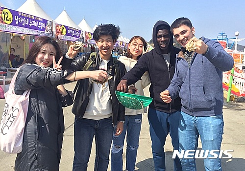 【대전=뉴시스】유순상 기자 = 배재대 한국어교육원이 21일 충남 서천에서 외국인 유학생을 대상으로 실시한 지역문화탐방에서 참가자들이 주꾸미를 들어보이고 기념촬영을 하고 있다.2017.03.21.(사진=배재대 제공)   ssyoo@newsis.com