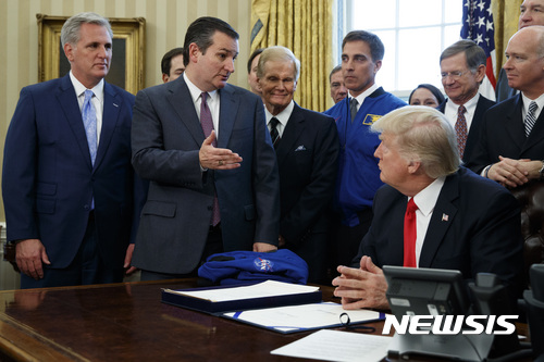 【워싱턴=AP/뉴시스】테드 크루즈 미국 상원의원이 21일(현지시간) 워싱턴 백악관 오벌오피스에서 동료의원들과 함께 도널드 트럼프 대통령의 나사(미항공우주국)예산 증액 법안 서명을 지켜보며 이야기하고 있다. 이날 트럼프 대통령은 나사의 예산은 195억달러로 증액하고 우주 및 화성에서의 유인탐사에 주력할 것을 명령하는 법안에 서명했다. 2017.03.22