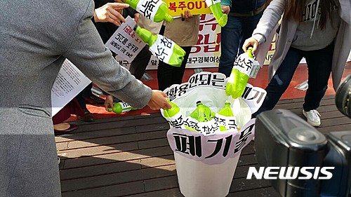 【대구=뉴시스】정창오 기자 = 대구지역 시민단체들이 22일 오전 대구 중구 대구백화점 광장에서 성차별과 상납강요 등 비리의혹이 제기된 주류업체 금복주에 대한 불매운동 시작을 알리는 기자회견을 마치고 금복주 제품을 폐기물로 버리는 퍼포먼스를 하고 있다. 2017.03.22. jco@newsis.com