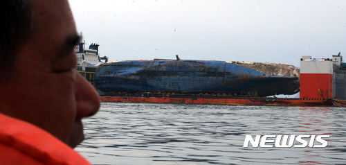 【진도=뉴시스】신대희 기자 = 26일 오전 전남 진도군 맹골수도에서 중국 인양업체 상하이샐비지가 반잠수식 선박에 부양된 세월호 선체의 배수 작업을 벌이고 있다. 세월호 미수습자 조은화양의 아버지 조남성씨가 세월호를 바라보고 있다. 세월호는 25일 오후 9시15분께 선체 전체가 해수면 위로 올랐다. 2017.03.26.&nbsp;&nbsp;&nbsp; sdhdream@newsis.com 