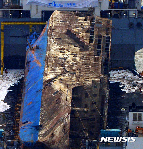 【진도=뉴시스】류형근 기자 = 지난 2014년 4월16일 침몰한 세월호가 처참했던 당시 상황을 말해 주듯 찢기고 녹슨 채 3년여만에 모습을 드러냈다. 반잠수선에 실린 세월호가 26일 오후 전남 진도군 동거차도 인근 사고해역에서 목포신항까지 87㎞ 마지막 항해를 앞두고 있다. 2017.03.26.&nbsp;&nbsp; hgryu77@newsis.com