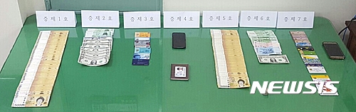 【파주=뉴시스】이경환 기자 = 경기 파주경찰서는 조건만남을 빙자해 1억원 상당을 인출해 중국으로 송금한 인출책 리모(42중국)씨 등 2명을 사기 혐의로 구속했다고 30일 밝혔다. 사진은 검거 당시 압수한 현금과 카드 등의 모습이다. 2017.03.30.&nbsp;&nbsp; lkh@newsis.com