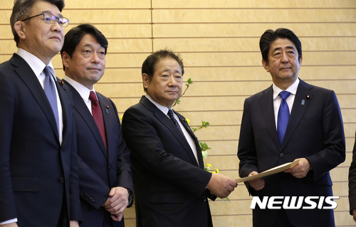 【도쿄=AP/뉴시스】일본 집권 자민당은 30일 북한의 위협이 새로운 단계로 접어든 것을 이유로 적(適) 기지를 선제 타격할 수 있는 능력인 '적기지 공격능력' 보유를 검토할 것을 정부에 공식 요청했다. 사진은 이마즈 히로시(今津寬) 자민당 안전보장조사회장이 이날 도쿄 총리관저에서 아베 신조(安倍晋三) 일본 총리에게 이러한 내용이 담긴 제언서를 전달하는 모습. 2017.03.30.