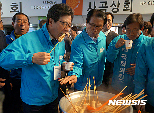 【의성=뉴시스】김진호 기자 = 유승민 바른정당 대선후보가 2일 경북 의성군 전통시장에서 권오을 경북도당위원장, 김진욱 상주·군위·의성·청송지역 4·12 국회의원 재선거 출마 후보와 함께 어묵을 먹고 있다.2017.04.02   kjh9326@newsis.com