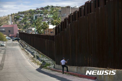 【노갈레스( 미 애리조나주) = AP/뉴시스】 미 애리조나주 노갈레스의 한 남성이 올 4월 1일 멕시코 국경의 울타리 너머 멕시코 노갈레스 쪽에 서 있는 아내와 딸과 이야기를 하고 있다. 2017.04.05