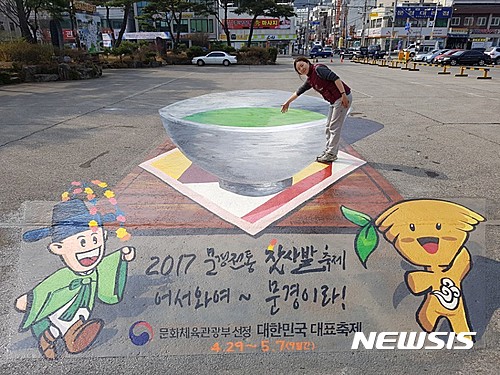 【문경=뉴시스】김진호 기자 = 경북 문경시가 도시환경 조성 및 구도심 활성화를 위해 점촌역 광장에 설치한 '트릭아트'의 전통찻사발 그림 속에 한 시민이 손을 넣어 보고 있다. 2017.04.04 (사진= 문경시 제공)&nbsp; photo@newsis.com