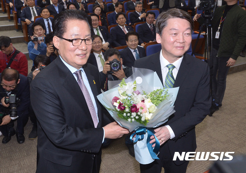 【서울=뉴시스】이영환 기자 = 5일 오전 서울 여의도 국회 제4회의실에서 열린 국민의당 최고위원-국회의원 연석회의에서 박지원(왼쪽) 대표가 안철수 후보에게 꽃다발을 전해주고 있다. 2017.04.05.&nbsp;&nbsp;&nbsp; 20hwan@newsis.com