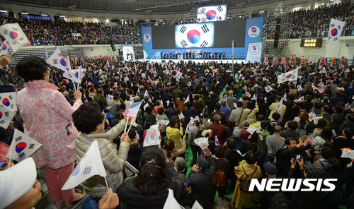 【서울=뉴시스】강종민 기자 = 5일 오후 서울 장충체육관에서 열린 새누리당 창당대회에서 태극기를 든 참석자들이 애국가를 부르며 태극기를 흔들고 있다. 2017.04.05. ppkjm@newsis.com