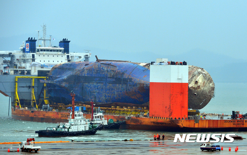 【목포=뉴시스】류형근 기자 = 인양된 세월호 육상거치를 앞둔 5일 오후 전남 목포시 목포신항에서 선박이 세월호와 모듈 트랜스포터를 일직선으로 배치하기 위해 반잠수선을 이동시키고 있다. 2017.04.05.&nbsp; hgryu77@newsis.com