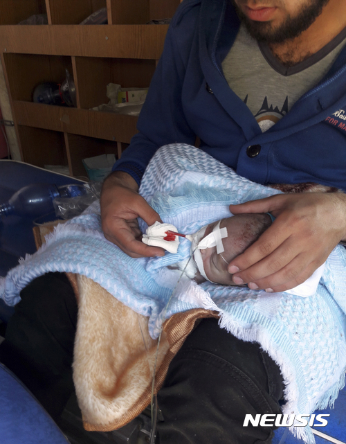 【 레이한리=AP/뉴시스】시리아 이들리브주 레이한리에서 4일(현지시간) 한 남성이 화학무기에 노출된 것으로 보이는 아기 환자를 돌보고 있다. 2017.04.06&nbsp; 