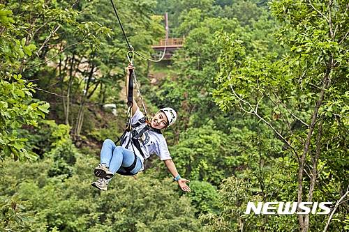【문경=뉴시스】김진호 기자 = 경북 문경시의 문경새재와 철로자전거 연계 프로그램이 한국관광공사의 '2017 춘계 레저스포츠 여행상품 공모전'에 선정됐다. 한 관광객이 문경에서 짚라인을 타고 있다. 2017.04.06 (사진= 문경시 제공) photo@newsis.com 