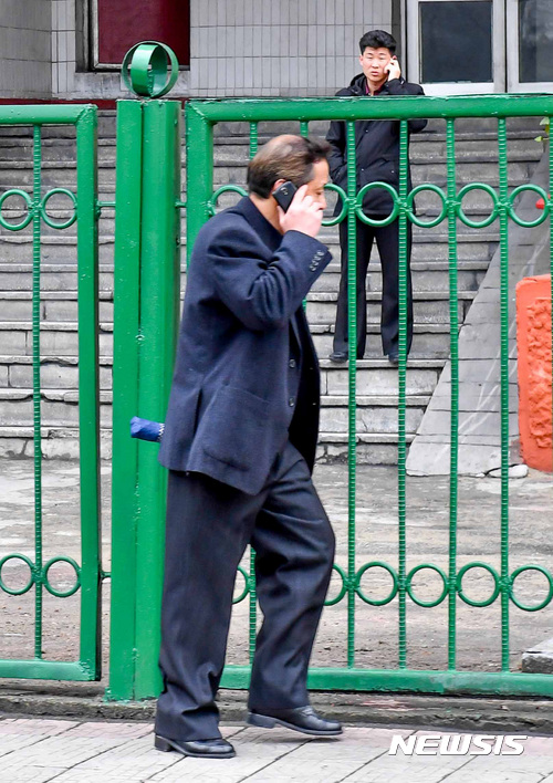 【평양=뉴시스】사진공동취재단 = 6일 평양 시민들이 길을 걸으며 휴대전화로 통화를 하고 있다. 2017.04.06.&nbsp; photo@newsis.com