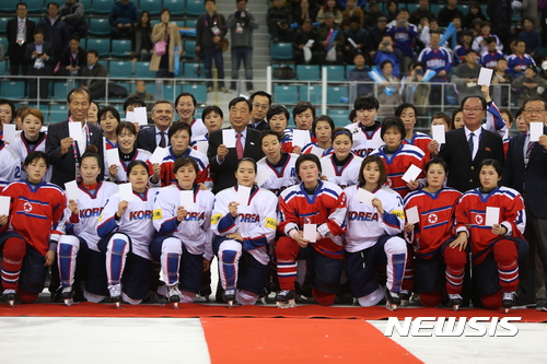 【강릉=뉴시스】김경목 기자 = 2017 국제아이스하키연맹(IIHF) 아이스하키 여자 세계선수권대회 디비젼 2 그룹 A(4월2~8일) 다섯째 날인 6일 오후 대한민국(유니폼 하얀색)과 북한(유니폼 빨간색)의 사상 첫 맞대결이 강원 강릉시 강릉 하키 센터에서 열린 뒤 양 팀 선수들과 이희범 2018 평창 동계올림픽대회 및 동계패럴림픽대회 조직위원회 위원장, 최문순 강원도지사, 북한 선수단 관계자 등이 기념사진을 촬영하고 있다. 한국이 3대0으로 북한을 이겼다. 북한은 이번 대회에서 1승 3패, 한국은 4승을 기록했다. 북한 선수단(선수 20명, 코치진 10명)은 지난 1일 북한에서 중국 베이징을 거쳐 중국 항공편으로 인천공항에 입국했다. 북한 선수단의 남한 입국은 2014년 10월 인천 아시안게임 이후 2년 6개월 만이다. 남한에서 여자 대표팀이 맞붙은 건 이번이 처음이다. 2017.04.06. photo31@newsis.com