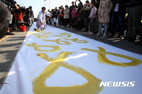 【목포=뉴시스】신대희 기자 = 8일 전남 목포신항만에서 열린 '세월호 미수습자 조기 수습 기원 문화 행사'에서 정태관 세월호 잊지않기 목포지역공동실천회의 상임공동대표가 서화 퍼포먼스를 벌이고 있다. 2017.04.08.&nbsp;&nbsp;&nbsp; sdhdream@newsis.com