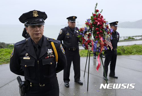 【샌프란시스코 = AP/뉴시스】 = 비가 내리는 샌프란시스코의 프레시디오 2차세계대전 서해안추모탑 앞에서 8일 (현지시간) 거행된 기념행사에서 경찰 의장대가 기념 헌화할 화환을 준비하고 있다. 1942년 일제의 태평양 전쟁 당시 열대정글에서 죽음의 65마일 행진 도중 죽거나 수용소에 도착해서 결국 죽어간 수많은 미군과 필리핀군 전사자들을 위한 추모행사에는 미군 장성들과 양국 생존자 재향군인들이 참석했다.