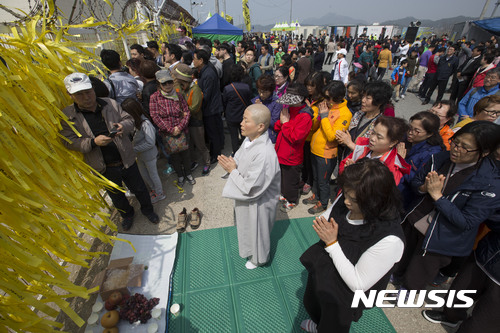 【목포=뉴시스】류형근 기자 = 세월호 육상 거치가 예정된 9일 오후 전남 목포시 목포신항만을 찾은 한 스님이 신도들과 함께 추모기도를 하고 있다. 2017.04.09. photo@newsis.com