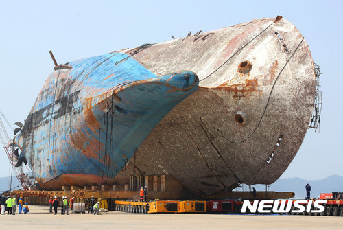 【목포=뉴시스】배동민 기자=11일 오후 전남 목포신항 철재부두에서 세월호 육상 거치작업 관계자들이 선체에서 모듈 트랜스포터로 흘러내린 펄에 섞인 유류품 등이 유실되지 않도록 대형 비닐을 깔고 세척작업을 하고 있다.&nbsp; 세월호 선체가 고정된 리프팅빔을 받침대 위에 거치한 뒤 모듈트랜스포터(MT)를 빼내는 작업이 끝나면 세월호 참사가 발생한 지 1천91일만에 모든 인양작업이 완료된다. 2017.04.11. photo@newsis.com 