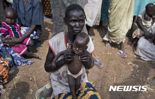 【말루알쿠엘=AP/뉴시스】남수단 말루알쿠엘에 있는 식량배급소에서 5일(현지시간) 한 여성이 생후 7개월된 아들을 안고 절박한 표정을 지으며 앉아 있다. 전쟁과 가뭄으로 인해 남수단 기아사태는 갈수록 악화되고 있다. 2017.04.11 