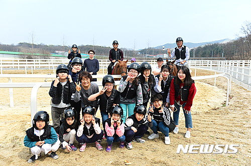 【양주=뉴시스】배성윤 기자 = 경기도 양주시는 은현면 도하리 657-1번지 농어촌테마공원 부지에 실내마장 1500㎡, 관리동 665.88㎡, 마사 380㎡, 실외마장 2550㎡, 보조마장 750㎡, 원형마장 314㎡, 외승로 0.34㎞ 등으로 구성된 승마장을 구성했다고 12일 밝혔다. 사진은 어린이들이 승마체험을 하고 기념촬영을 하는 모습이다. 2017.04.12.(사진=양주시청 제공)&nbsp; photo@newsis.com 