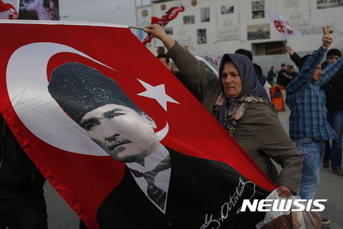 【이스탄불=AP/뉴시스】터키 여성이 12일(현지시간) 이스탄불에서 터키 공화국을 세운 무스타파 케말 아타튀르크의 사진이 있는 국기를 흔들고 있다. 터키는 오는 16일 레제프 타이이프 에르도안 터키 대통령의 권한을 강화하는 개헌안 국민투표를 치른다. 2017.04.13