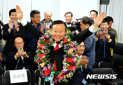 【상주=뉴시스】김진호 기자 = 12일 경북 상주·군위·의성·청송 국회의원 재선거에서 승리한 자유한국당 김재원 당선자가 상주선거사무소에서 꽃다발을 목에 걸고 승리를 선언하고 있다. 2017.04.13&nbsp;&nbsp; kjh9326@newsis.com&nbsp; 